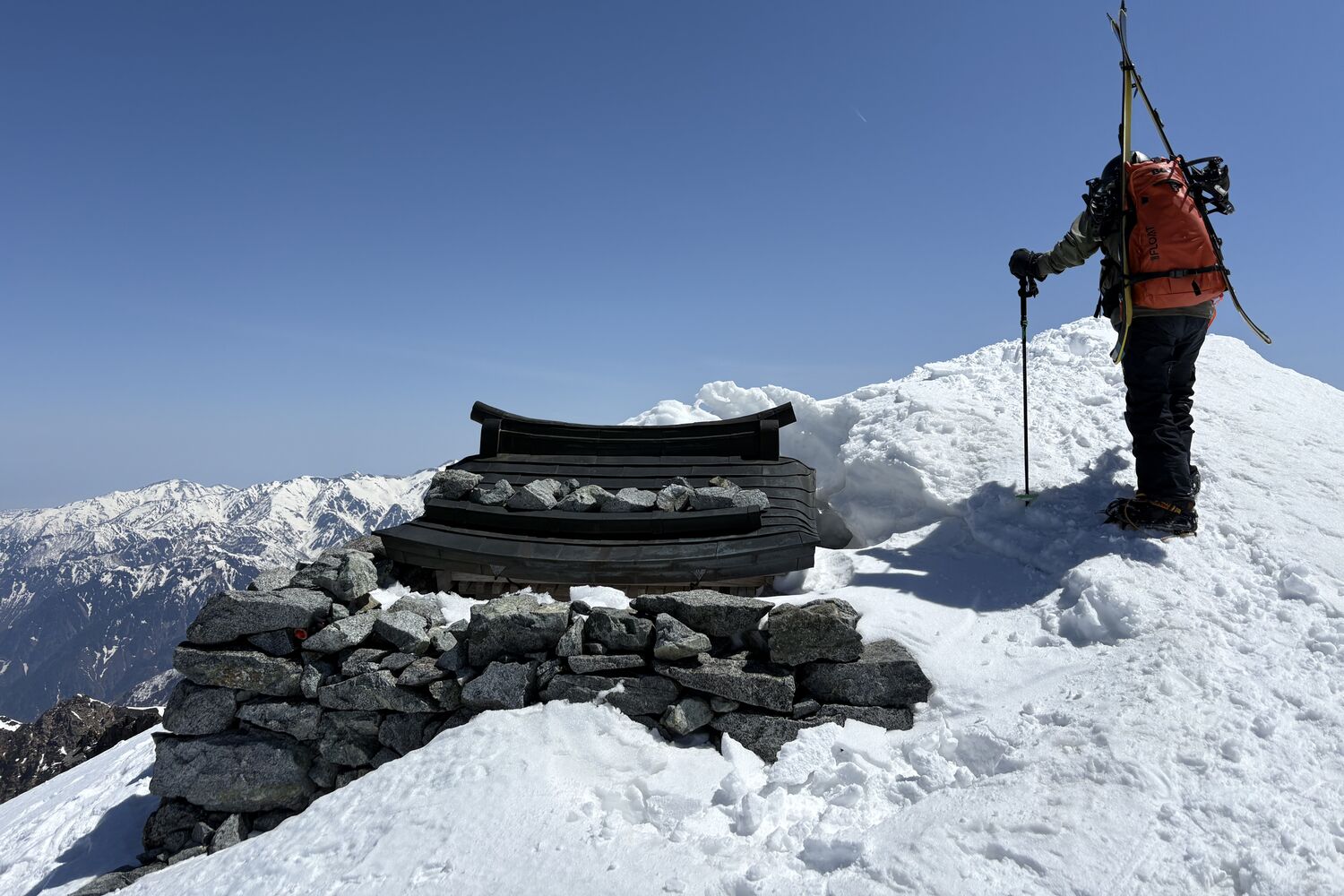 Splitboarder at a summit shrine in the Japanese Alps
