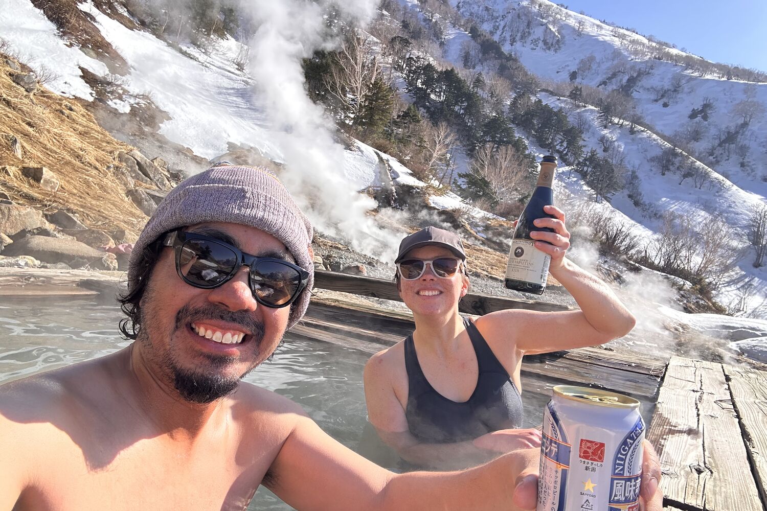 Relaxing in an outdoor onsen with snowy mountain views after a tour